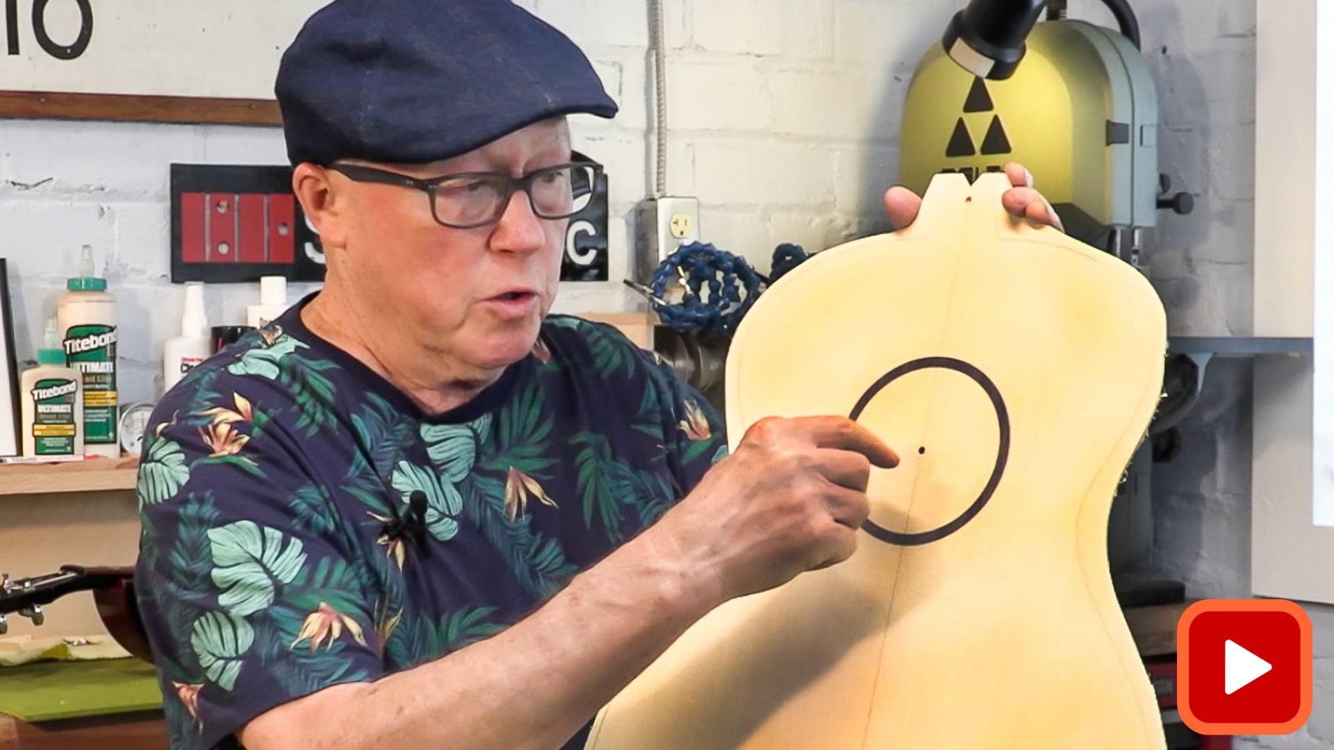 Man pointing to inlaid rosette on acoustic guitar top